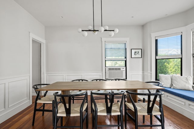 dining space featuring dark wood-type flooring, a chandelier, cooling unit, and a wealth of natural light