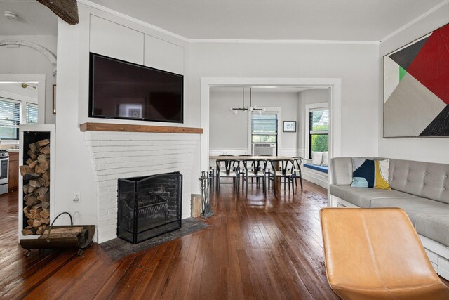 living room featuring cooling unit, crown molding, dark hardwood / wood-style floors, and a fireplace