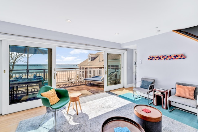 interior space with recessed lighting, a water view, and wood finished floors