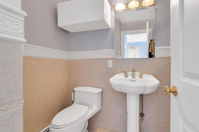 bathroom with tile walls, visible vents, a wainscoted wall, and toilet