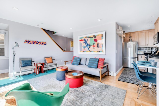 living room featuring baseboards, recessed lighting, and light wood-style flooring