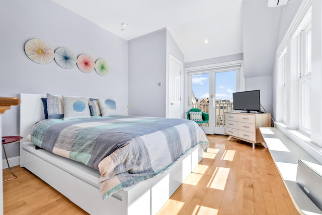 bedroom with light wood-type flooring, access to outside, and lofted ceiling