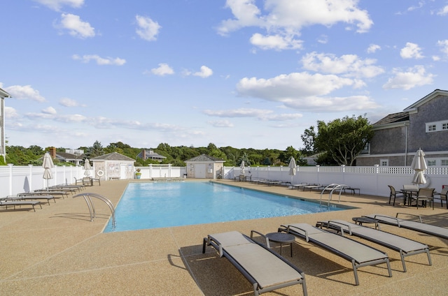 view of swimming pool with an outdoor structure and a patio