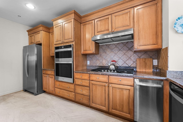 kitchen featuring tasteful backsplash, appliances with stainless steel finishes, and dark stone counters