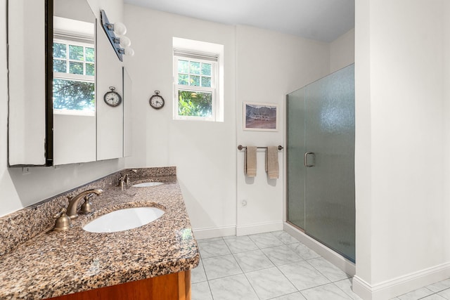 bathroom with an enclosed shower, vanity, and a wealth of natural light