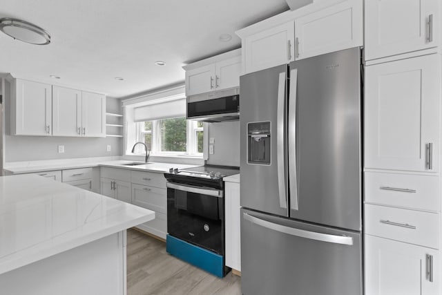 6 Januit St, Sandwich, MA 02563 - kitchen with appliances with stainless steel finishes, a sink, light wood-style floors, open shelves, and white cabinets