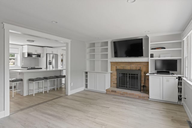 6 Januit St, Sandwich, MA 02563 - living room with light wood finished floors, a brick fireplace, built in features, and baseboards