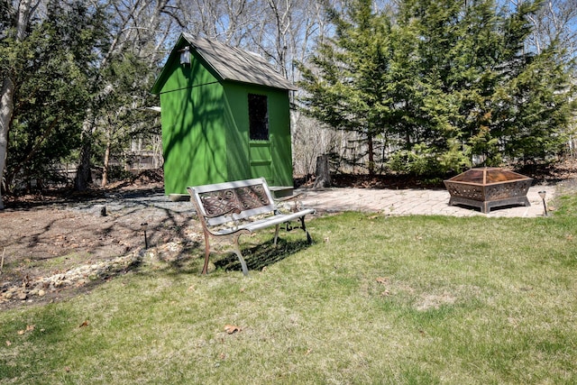 view of yard featuring a fire pit, a shed, an outdoor structure, and a patio