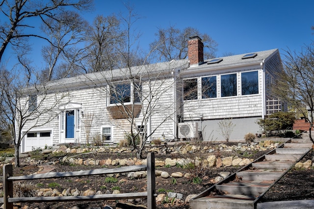 bi-level home featuring a chimney and a garage