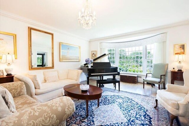 sitting room featuring a notable chandelier, ornamental molding, and wood-type flooring