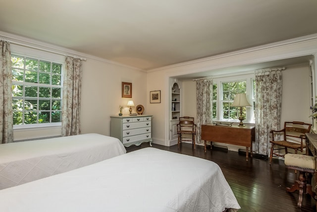 bedroom with crown molding and dark hardwood / wood-style flooring