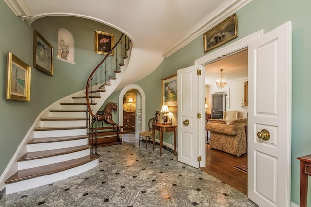 stairs with crown molding and an inviting chandelier