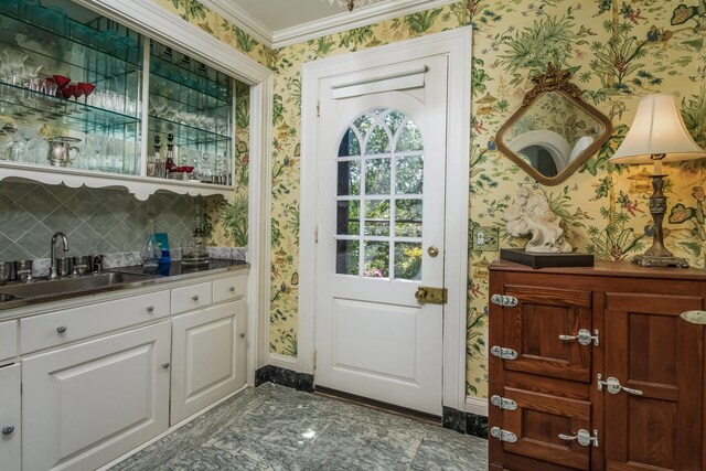 doorway featuring sink and crown molding