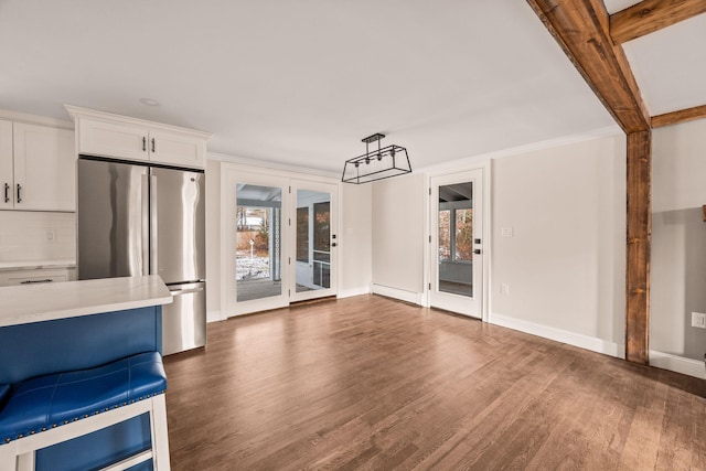 unfurnished living room featuring plenty of natural light, baseboard heating, dark hardwood / wood-style flooring, and crown molding