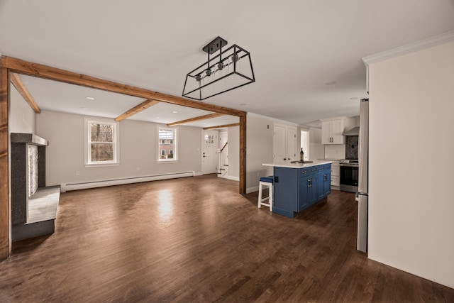 unfurnished living room with sink, beam ceiling, baseboard heating, and dark hardwood / wood-style flooring