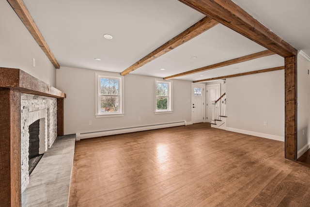 unfurnished living room with a baseboard radiator and hardwood / wood-style floors