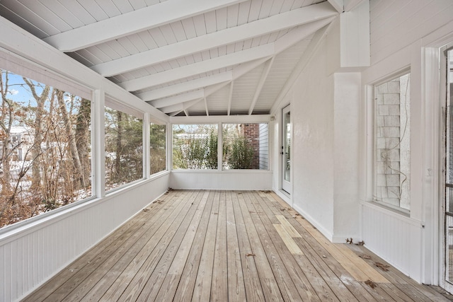 unfurnished sunroom featuring vaulted ceiling with beams