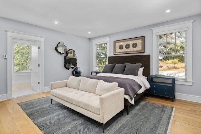 bedroom with light hardwood / wood-style floors and ensuite bath