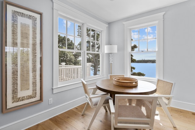 dining room featuring a water view and wood-type flooring