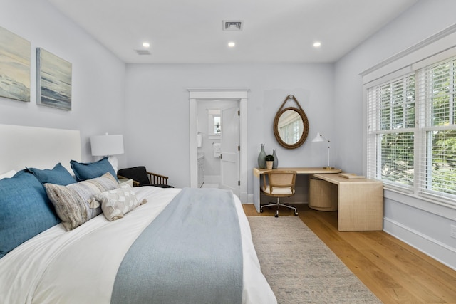 bedroom featuring connected bathroom, light hardwood / wood-style flooring, and multiple windows