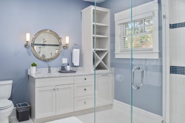 bathroom with vanity, toilet, and a shower with shower door