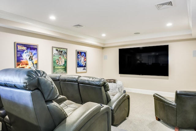 carpeted cinema room with a raised ceiling and crown molding