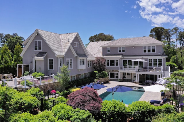 back of property with a fenced backyard, a patio, stairway, and a pool with connected hot tub