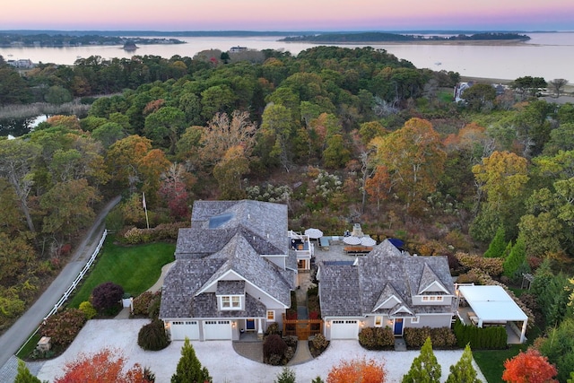 aerial view at dusk featuring a water view