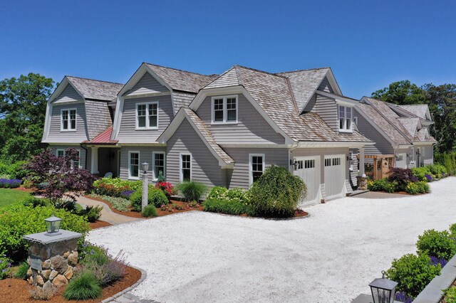 shingle-style home featuring driveway and an attached garage