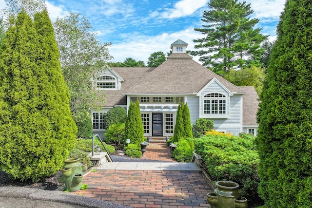 view of front of house with french doors and roof with shingles