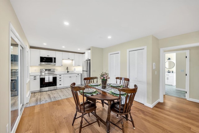 dining room featuring recessed lighting, baseboards, a baseboard heating unit, and light wood-style floors