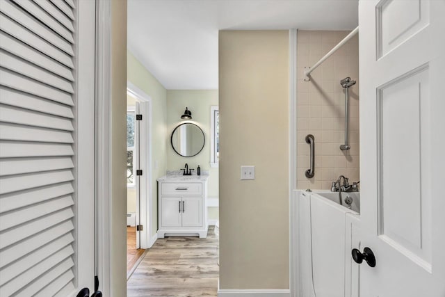 bathroom with vanity, wood finished floors, and baseboards