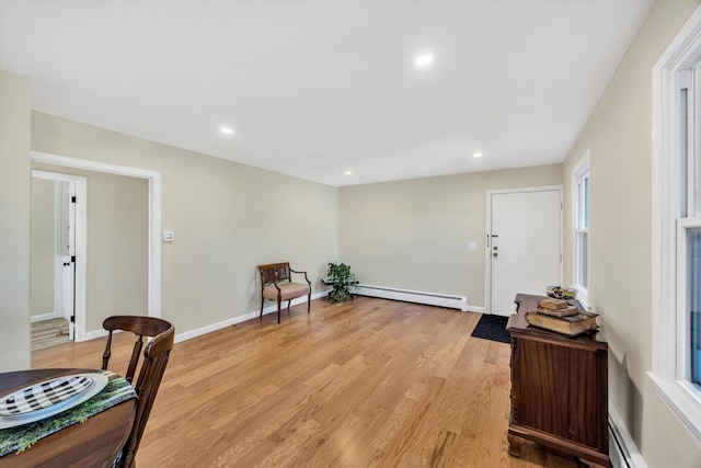 sitting room with a baseboard heating unit, recessed lighting, and light wood-style floors