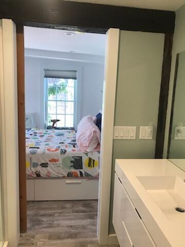 bedroom with sink and hardwood / wood-style floors