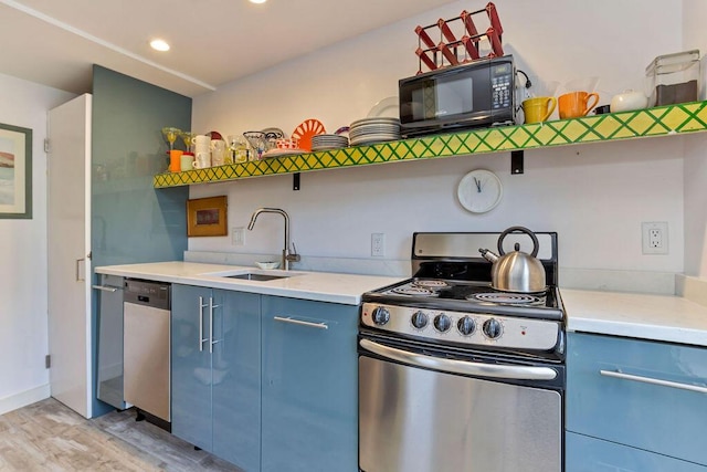 kitchen featuring sink, appliances with stainless steel finishes, light hardwood / wood-style flooring, and blue cabinets