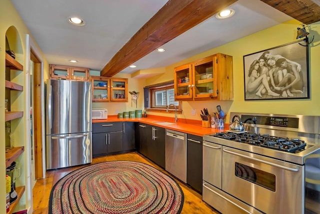 kitchen with sink, light hardwood / wood-style flooring, beamed ceiling, and stainless steel appliances