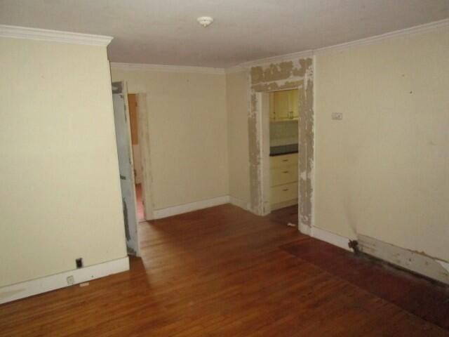 unfurnished room with crown molding and dark hardwood / wood-style flooring