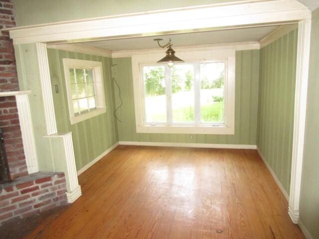 unfurnished living room featuring a brick fireplace and hardwood / wood-style floors