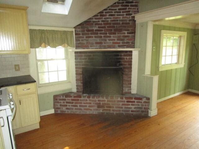 unfurnished living room with a brick fireplace and hardwood / wood-style floors