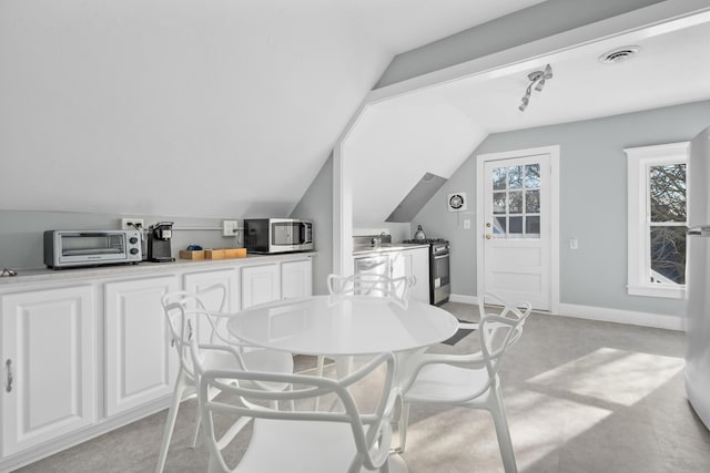 dining space featuring lofted ceiling and sink