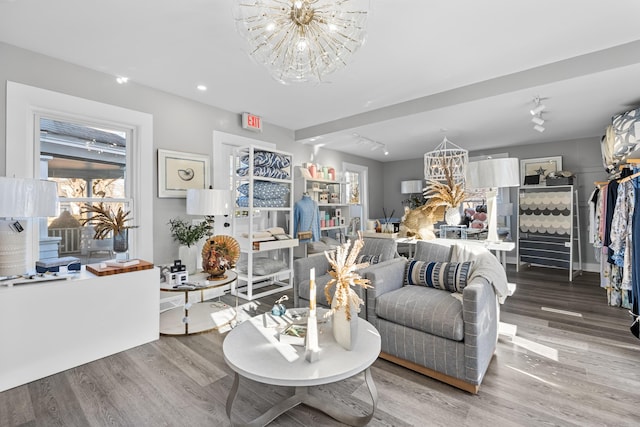 living room featuring hardwood / wood-style flooring, rail lighting, and a chandelier