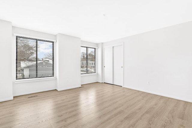 unfurnished bedroom with visible vents, baseboards, and wood finished floors