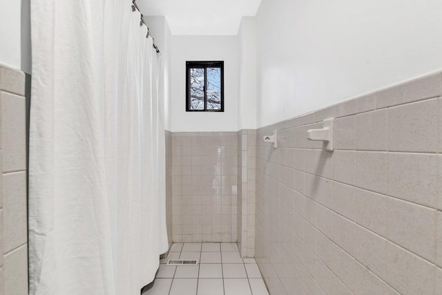 bathroom featuring tile walls, wainscoting, and tile patterned flooring