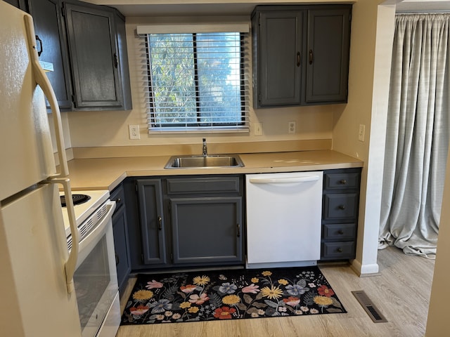 kitchen featuring white appliances, light hardwood / wood-style floors, and sink