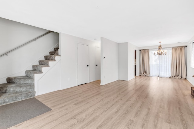 329 Main St Unit 30, Hyannis, MA 02601 - unfurnished living room with a chandelier, light wood finished floors, stairway, and baseboards