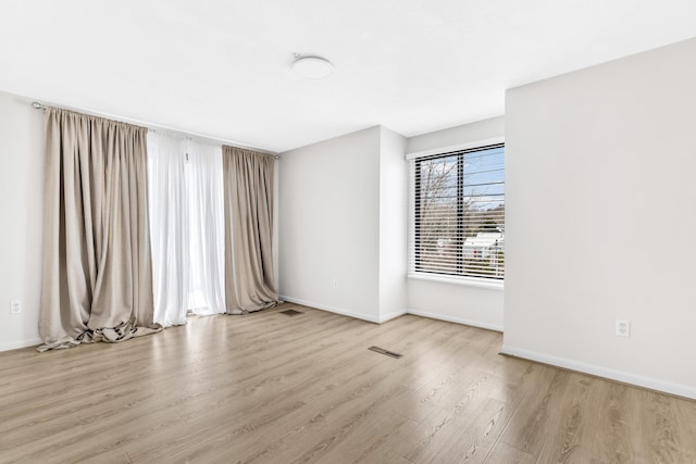 spare room featuring wood finished floors and baseboards