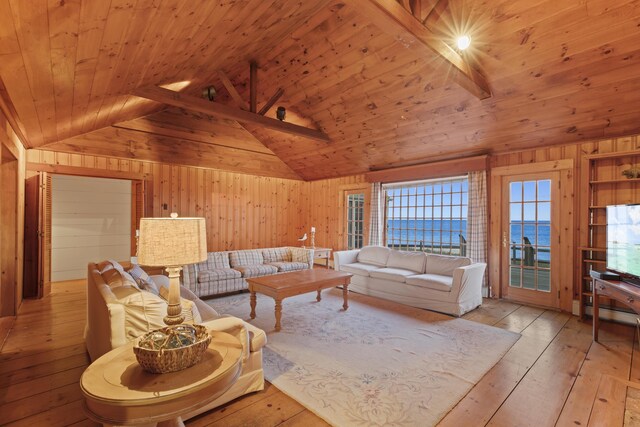 living room with wood ceiling, light wood-type flooring, beam ceiling, and wooden walls