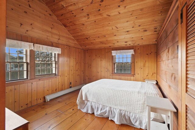 bedroom with wood ceiling, a baseboard heating unit, and wooden walls