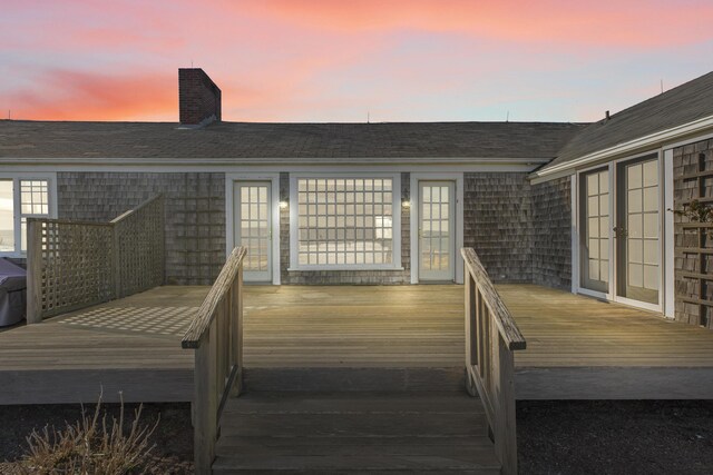 deck at dusk featuring french doors