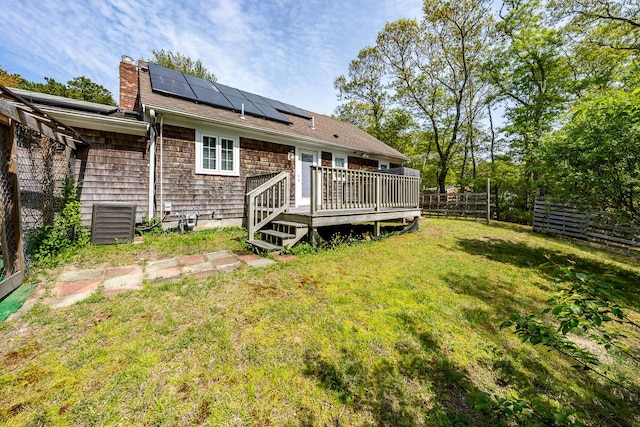121 S Yarmouth Rd, Dennis, MA 02638 - rear view of property featuring a deck, solar panels, and a chimney